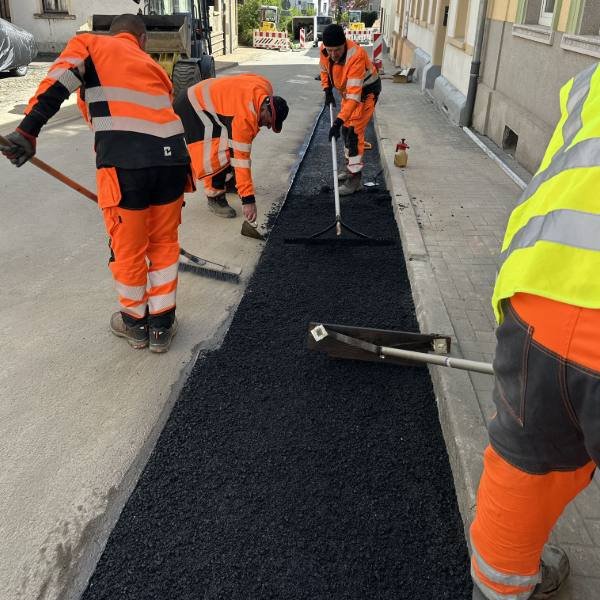 Einbau der Asphaltdeckschicht von Hand